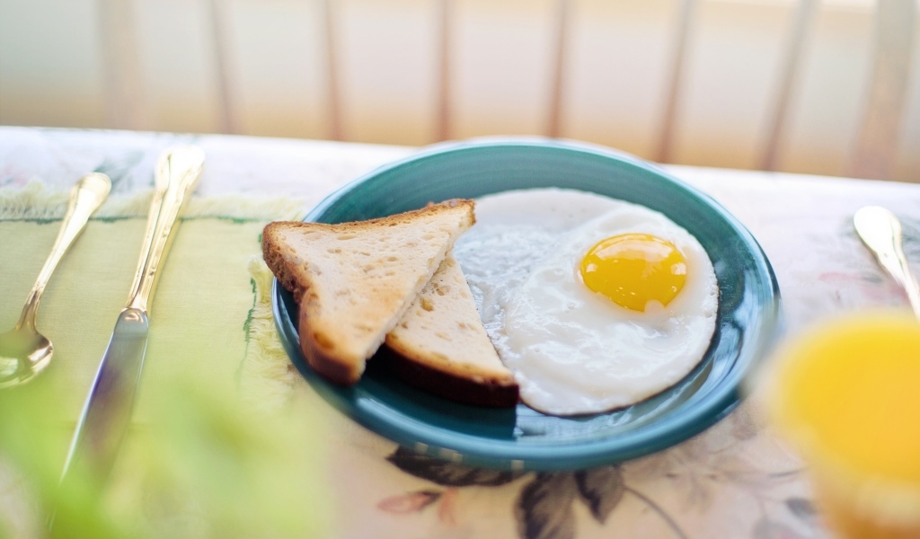 Яичница с хлебом на столе на завтрак 