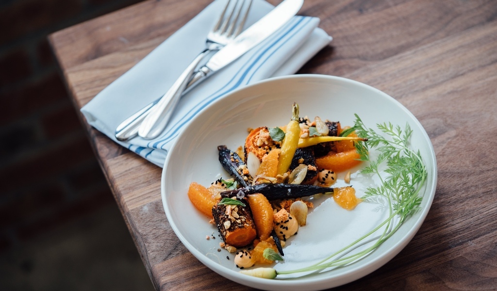 Жареные овощи на тарелке со столовыми приборами