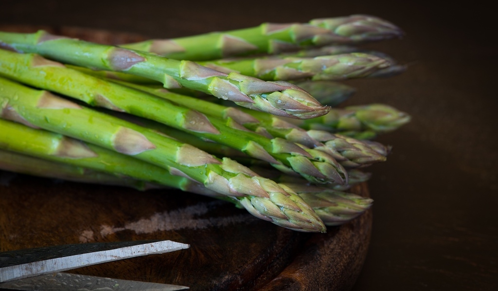 Зеленые стебли спаржи на столе
