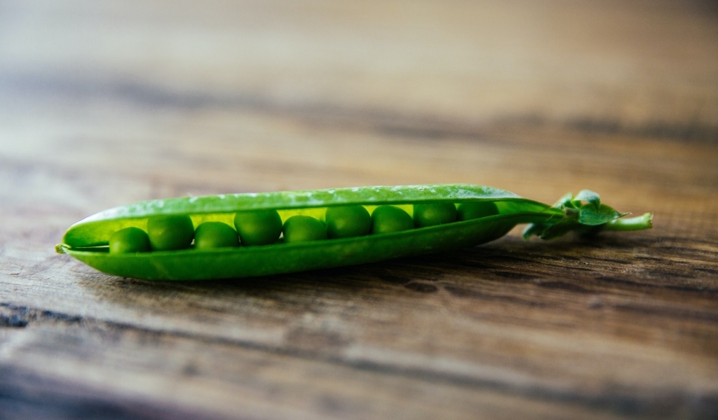 Зеленый горох на деревянном столе
