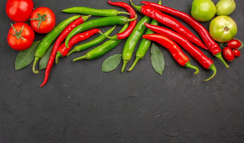 Острый перец чили на столе с помидорами