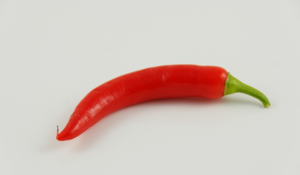 Острый красный перец на сером фоне