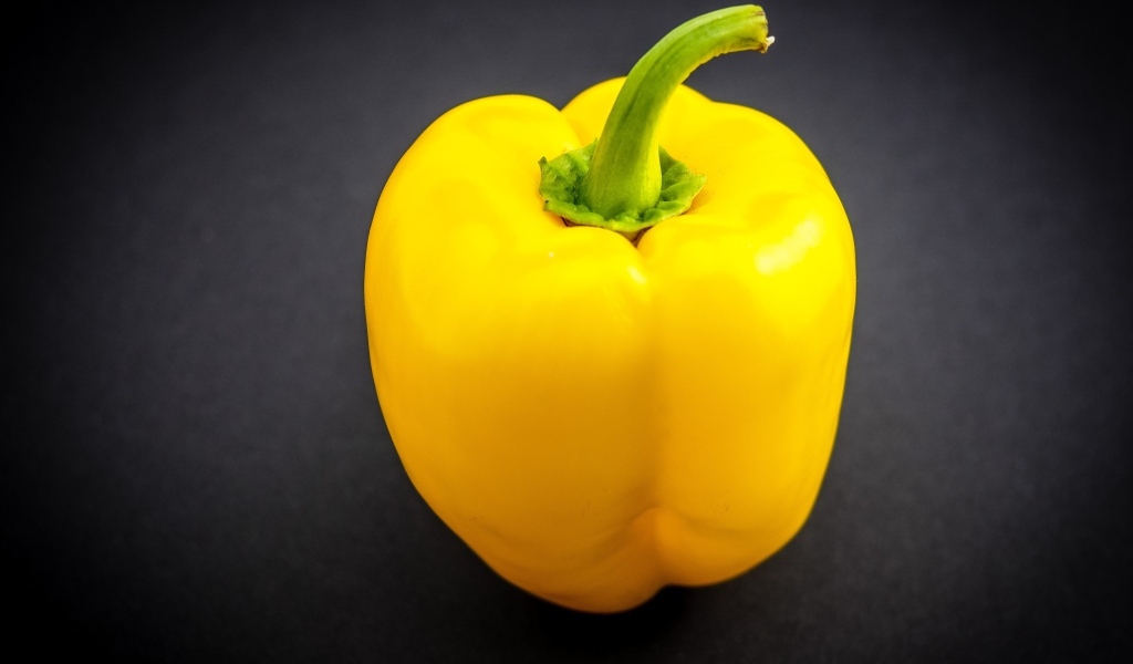 Большой желтый сладкий перец на сером фоне