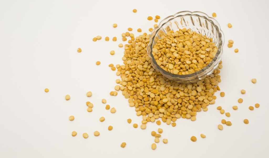 Чечевица рассыпана на белом фоне