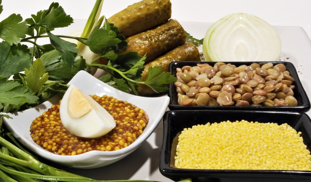 Пшено на столе с огурцами луком и горчицей