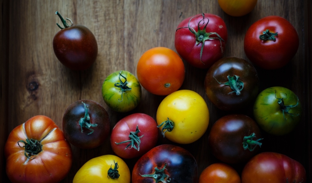 Разноцветные помидоры на деревянном столе