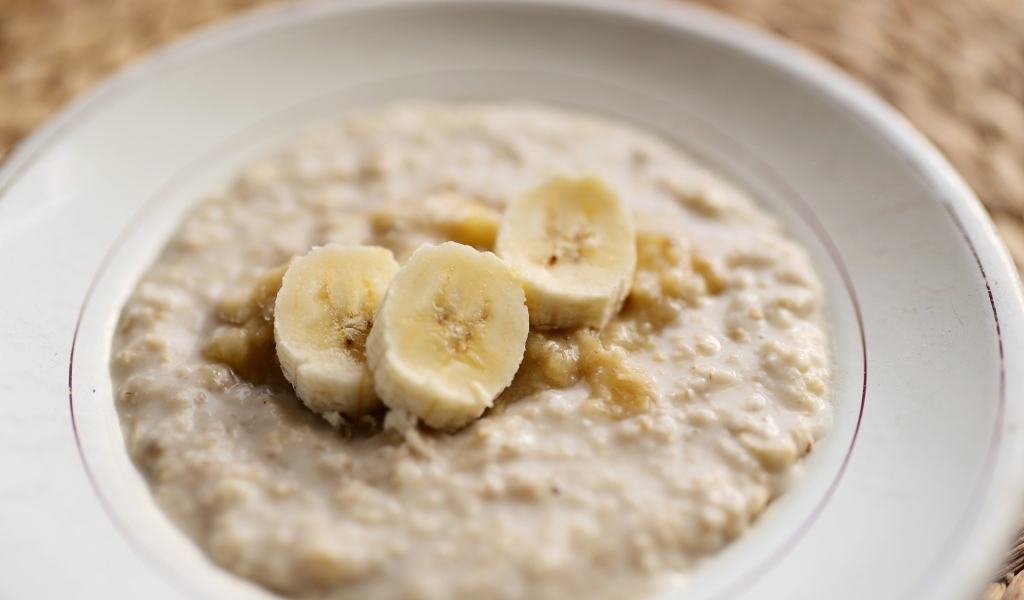 Овсяная каша с кусочками банана в тарелке