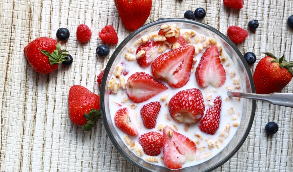 Овсянка с молоком в тарелке с ягодами малины