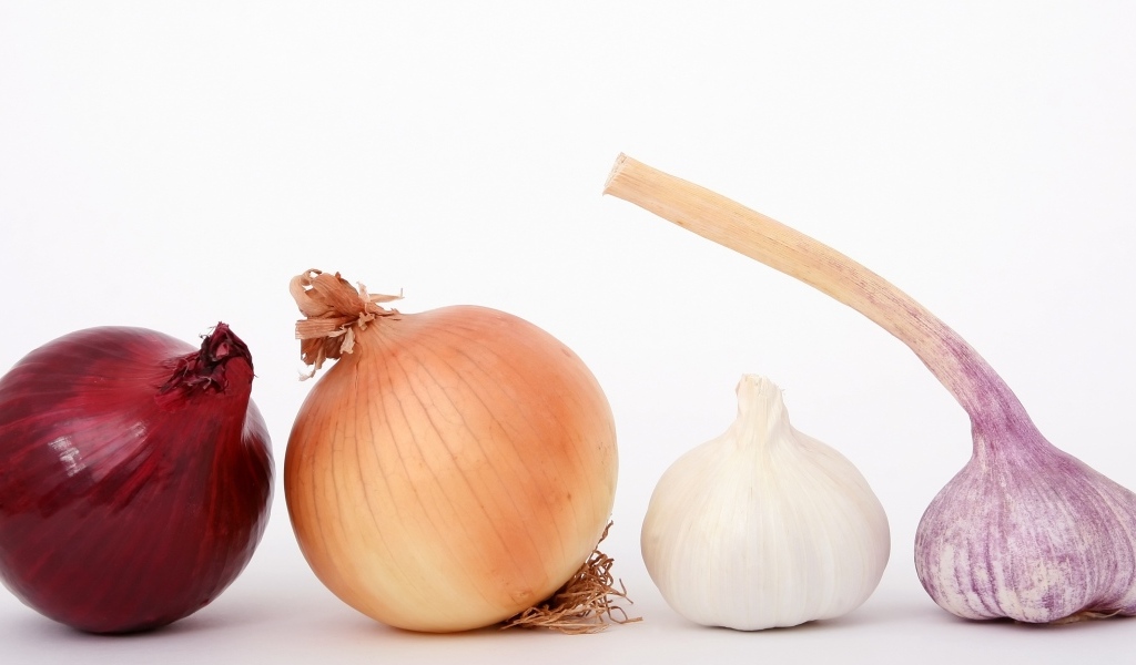 Репчатый лук с чесноком на белом фоне