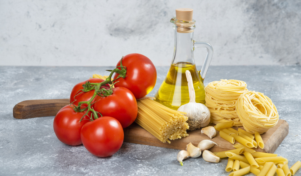 Паста, помидоры и масло на столе