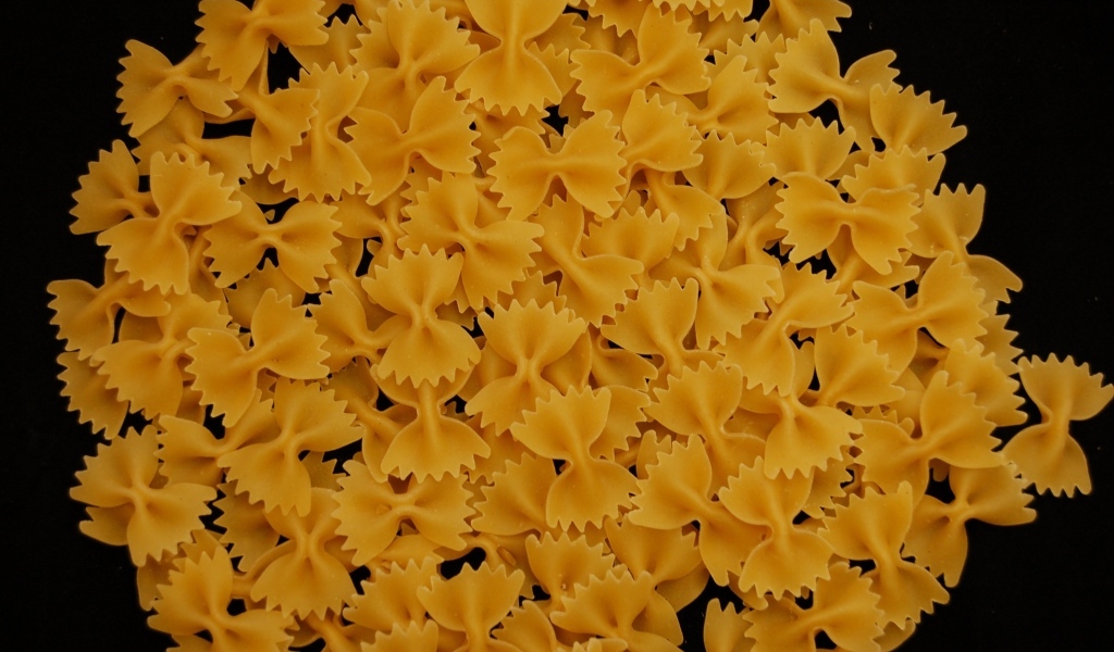 Макароны в форме бантиков на черном фоне