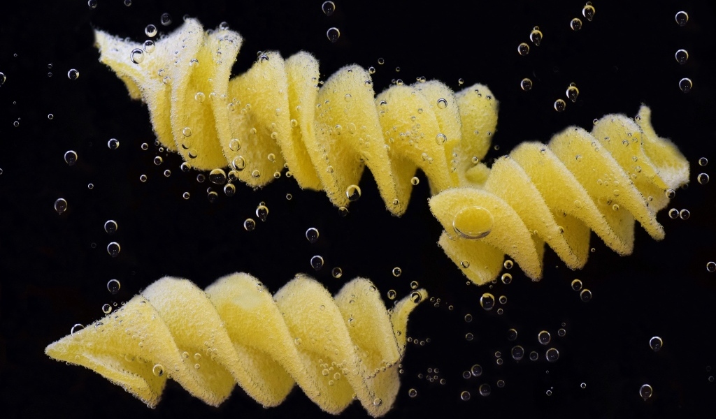 Макароны в воде на черном фоне