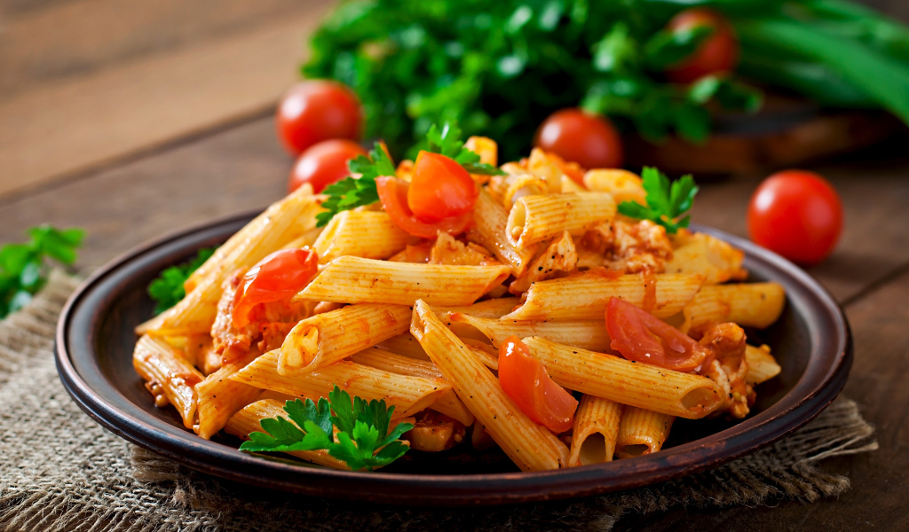 Макароны на тарелке с помидорами и петрушкой