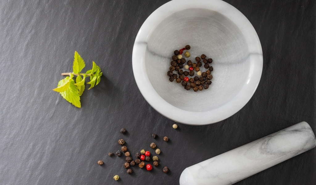 Перец горошком в ступе на сером столе