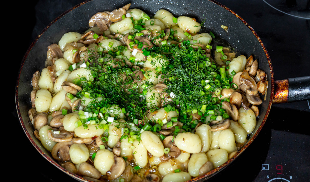 Картофель с шампиньонами и зеленым луков в сковороде