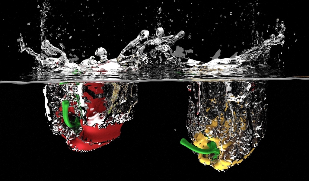 Красный и желтый перец в воде на черном фоне