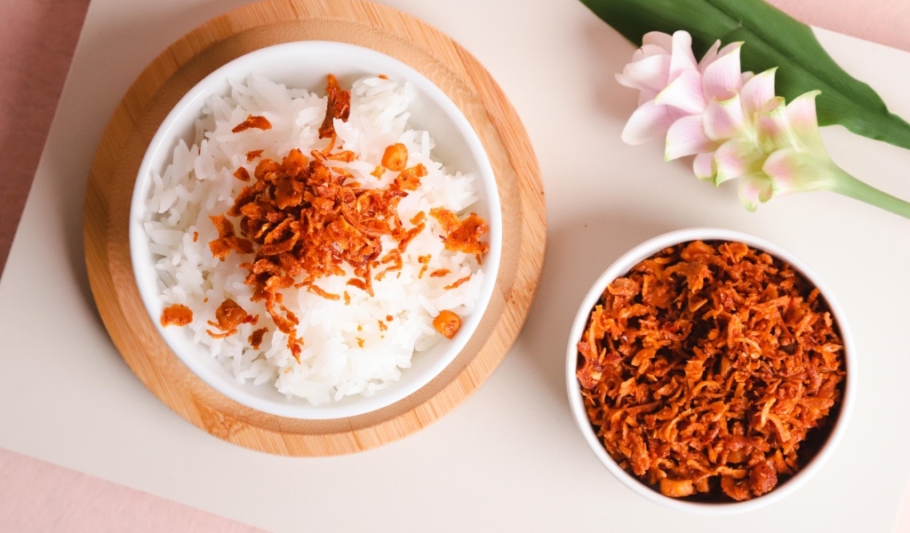 Рис с луком на столе с цветком