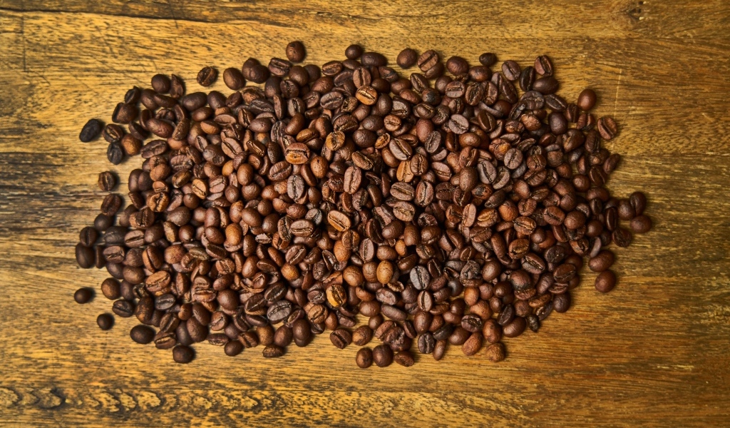 Жареные кофейные зерна на деревянном столе