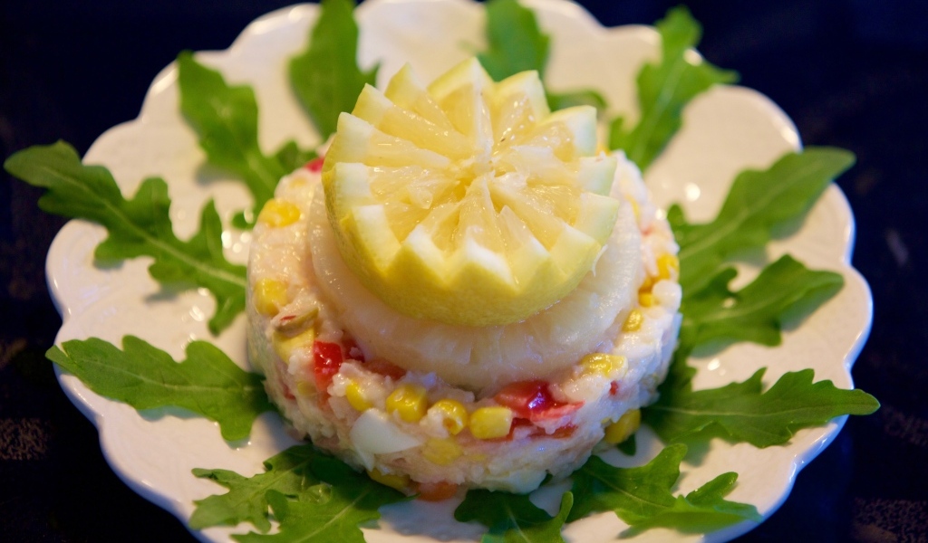 Салат на тарелке с лимоном и рукколой