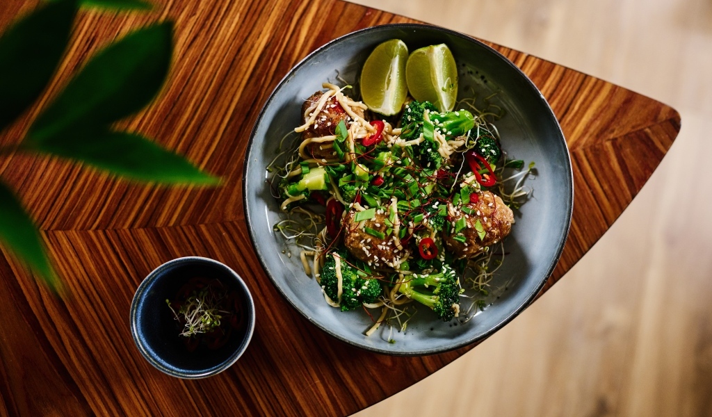 Салат на тарелке с кусочками лайма