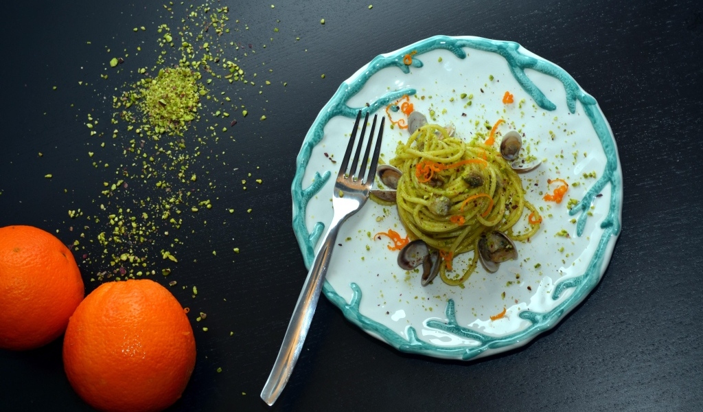 Спагетти с морепродуктами на столе с апельсинами