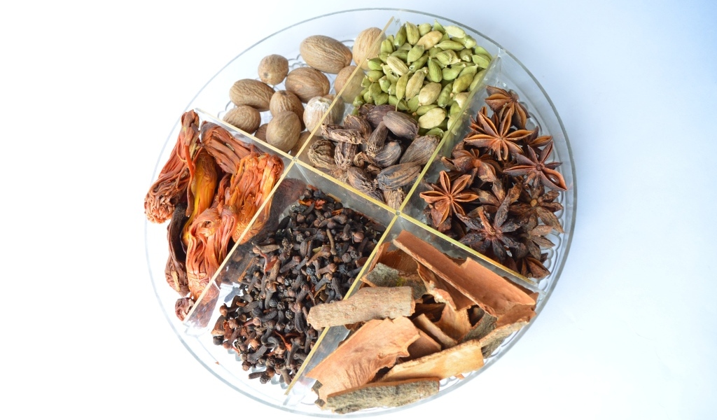 Пряные специи на стеклянной тарелке на столе