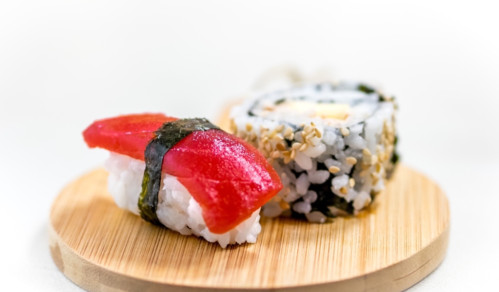 Суши на доске на белом фоне