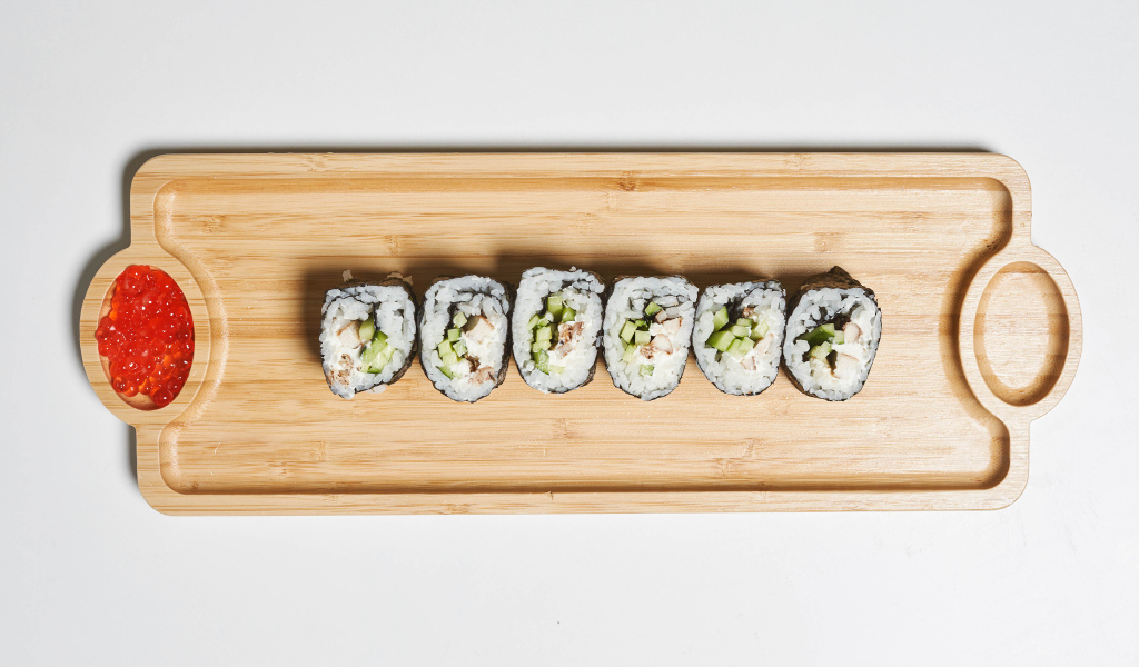 Суши на деревянной доске с  красной икрой