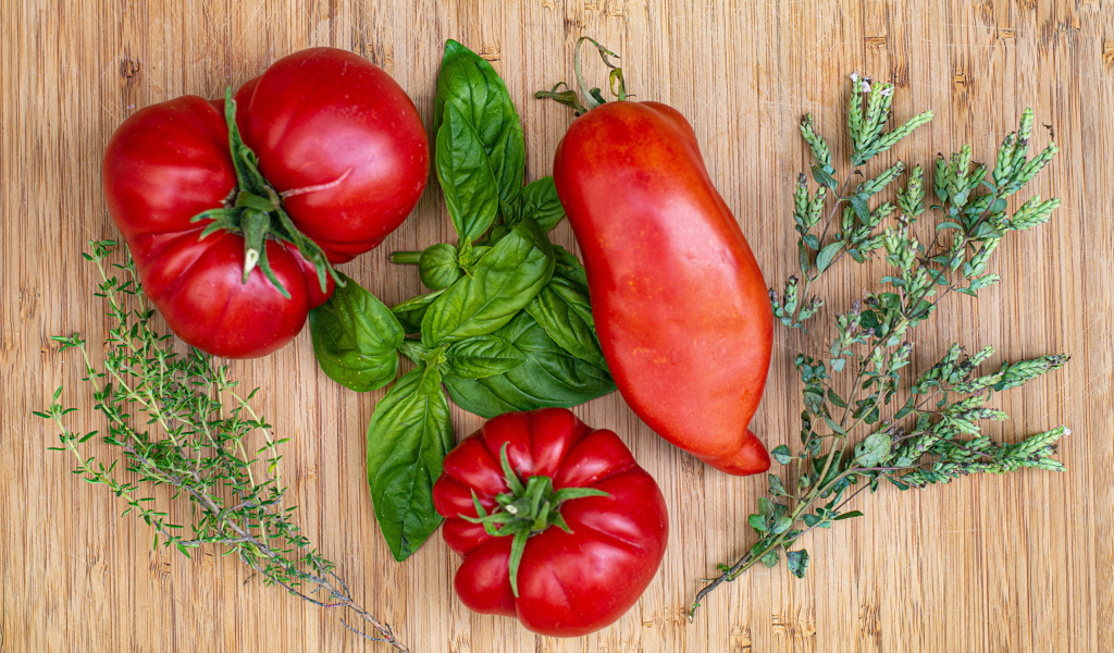 Помидоры  на разделочной доске с базиликом