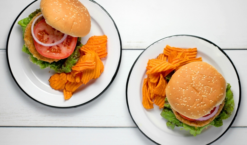 Два гамбургера на тарелке с чипсами