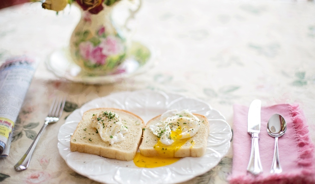 Два куска хлеба с яйцом на тарелке на завтрак