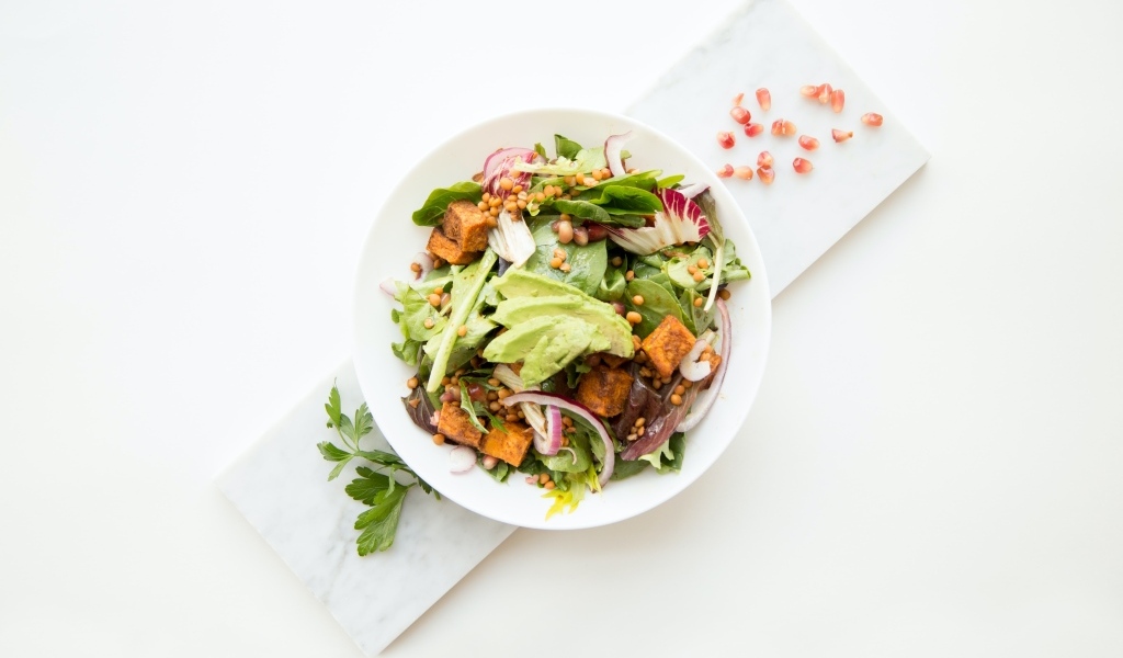 Овощной салат в тарелке на белом столе