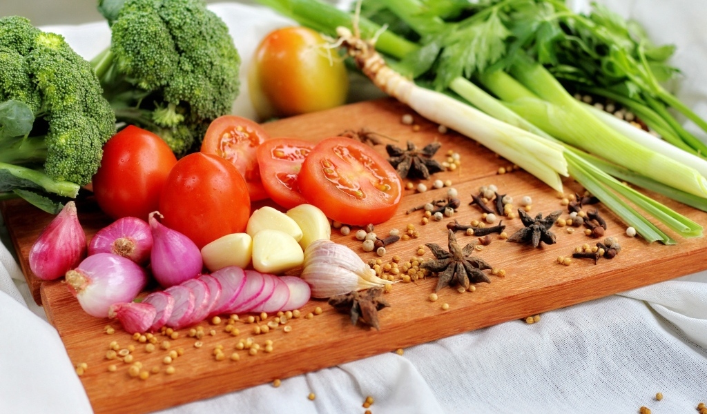 Овощи с зеленью на разделочной доске 