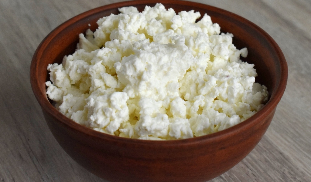 Деревянная миска с творогом на столе
