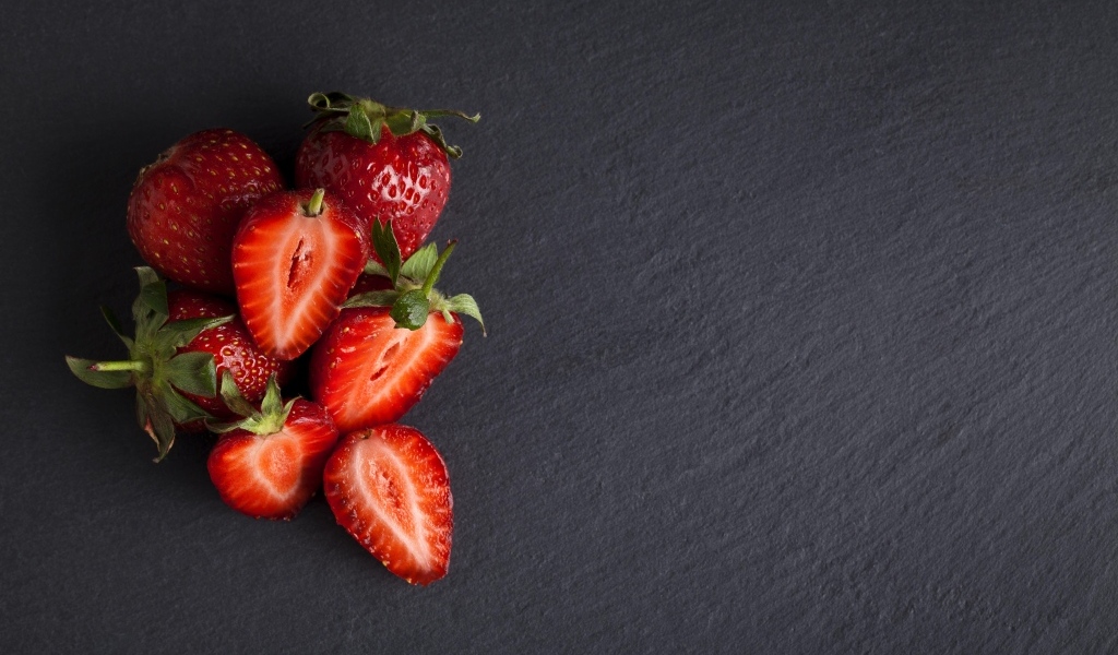 Горсть спелой клубники на сером столе