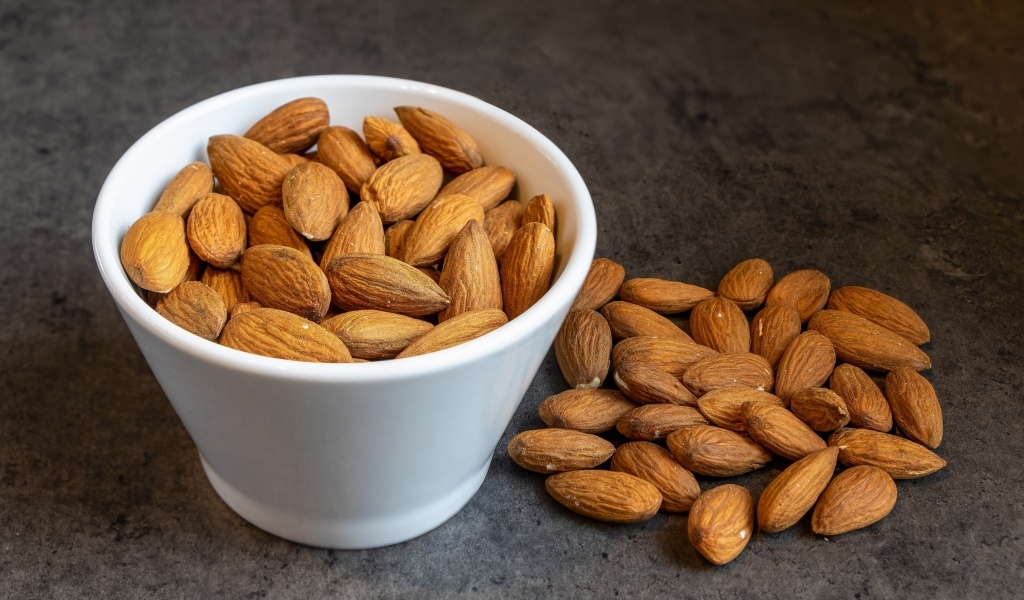 Миндальные орехи в белой пиале на столе