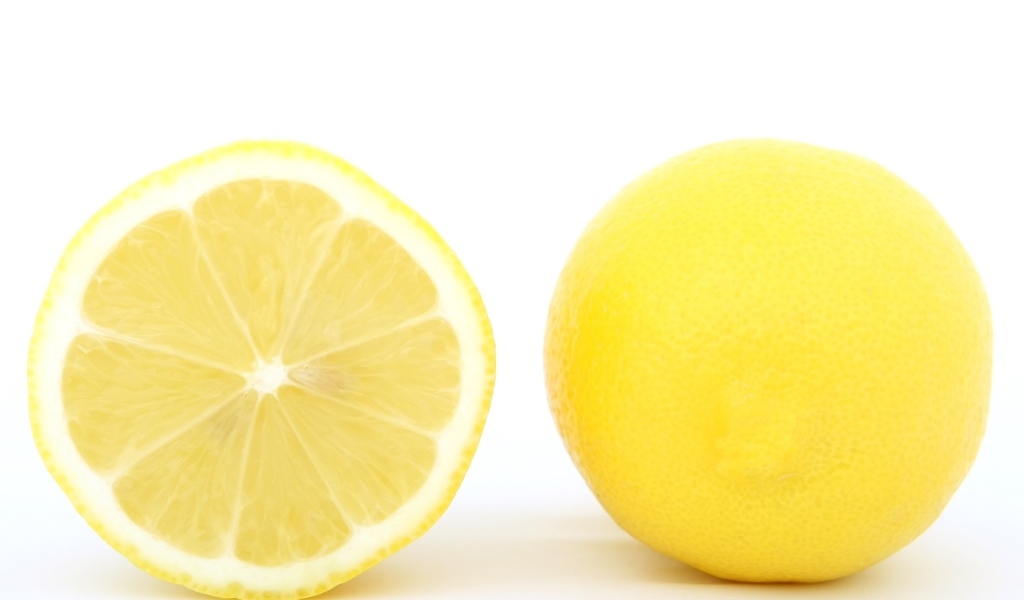 Большой желтый спелый лимон на белом фоне