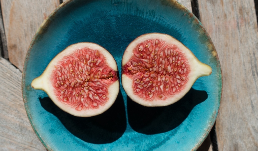 Половинки инжира на голубой тарелке