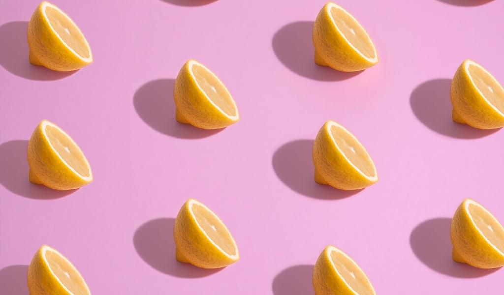 Половинки лимона на розовом фоне