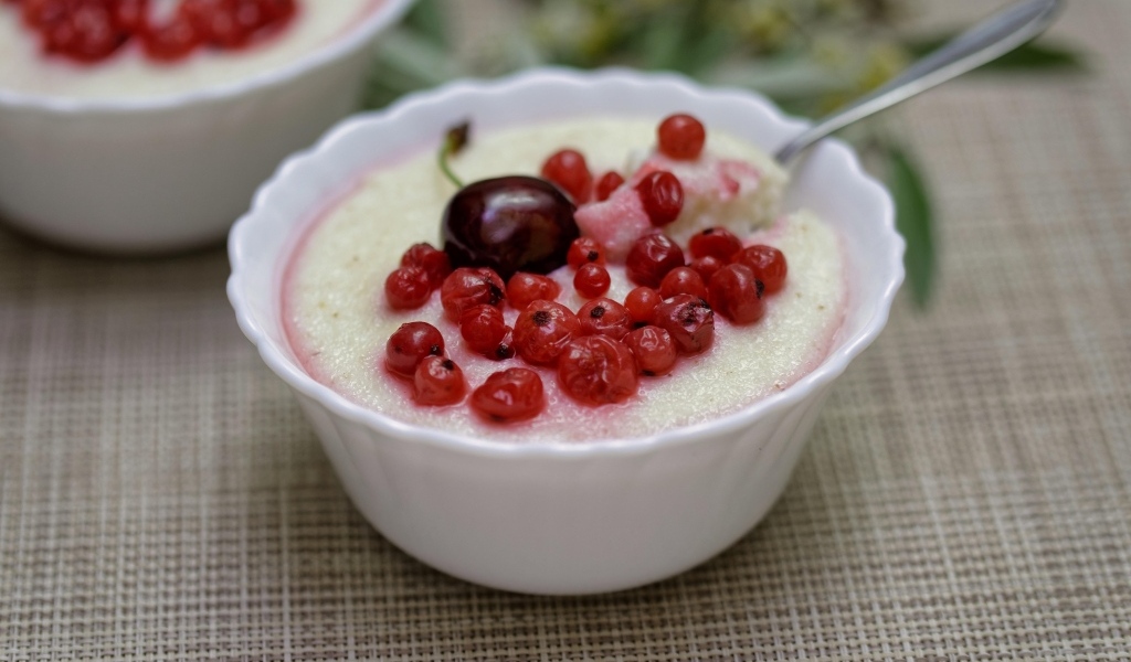 Манная каша в тарелке с ягодами