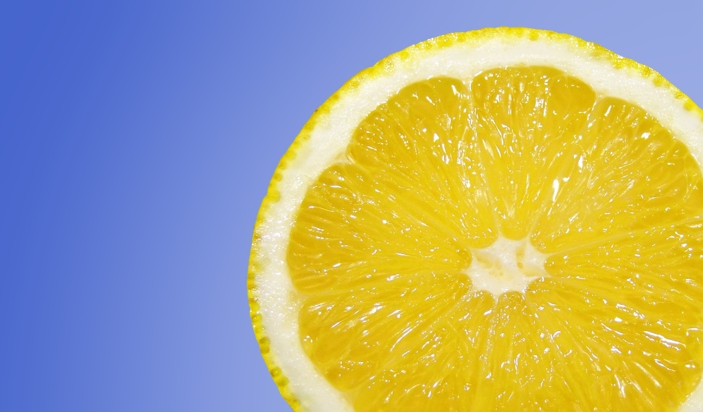 Кислый желтый лимон на синем фоне