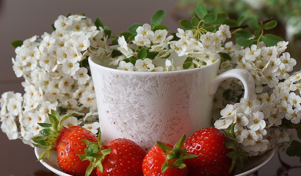 Клубника на тарелке с чашкой и белыми цветами