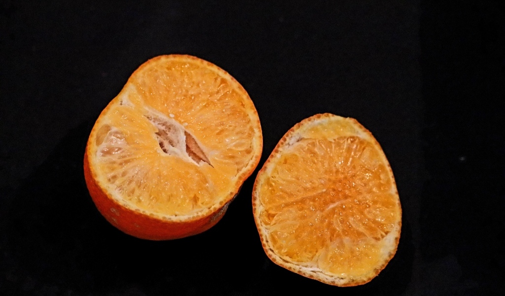 Мандарин на черном фоне крупным планом