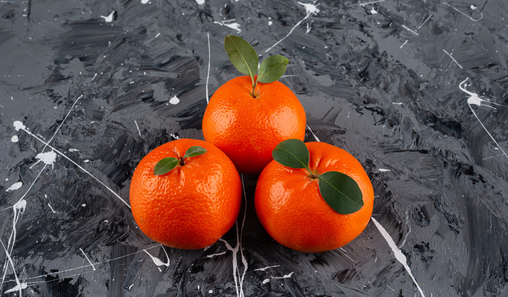 Три мандарина на сером столе