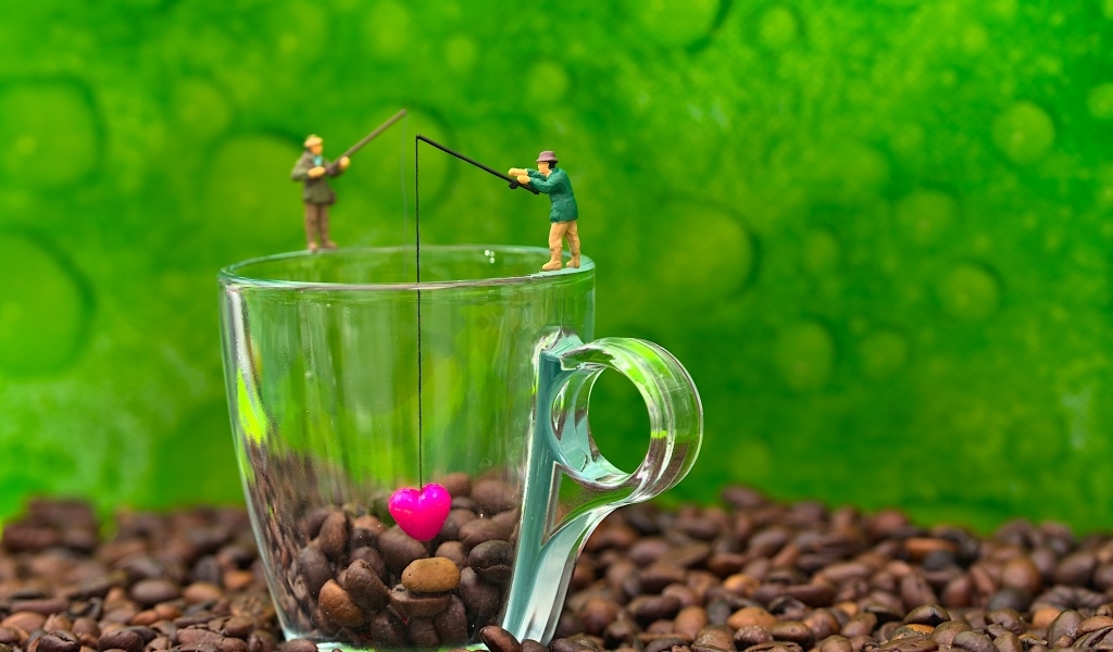 Две фигурки на стеклянной чашкой с кофейными зернами