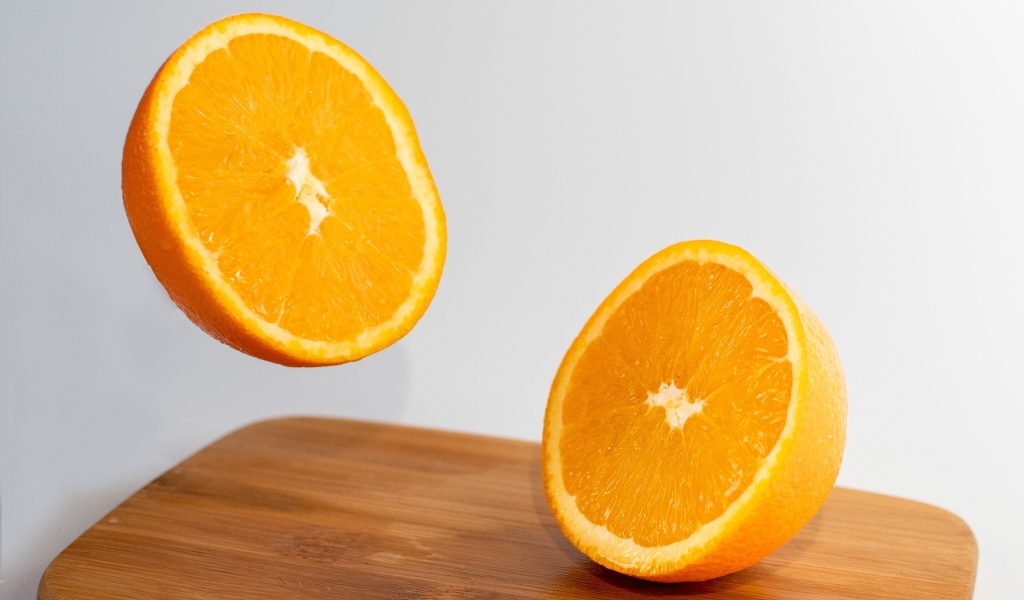 Две половинки апельсина на деревянной доске