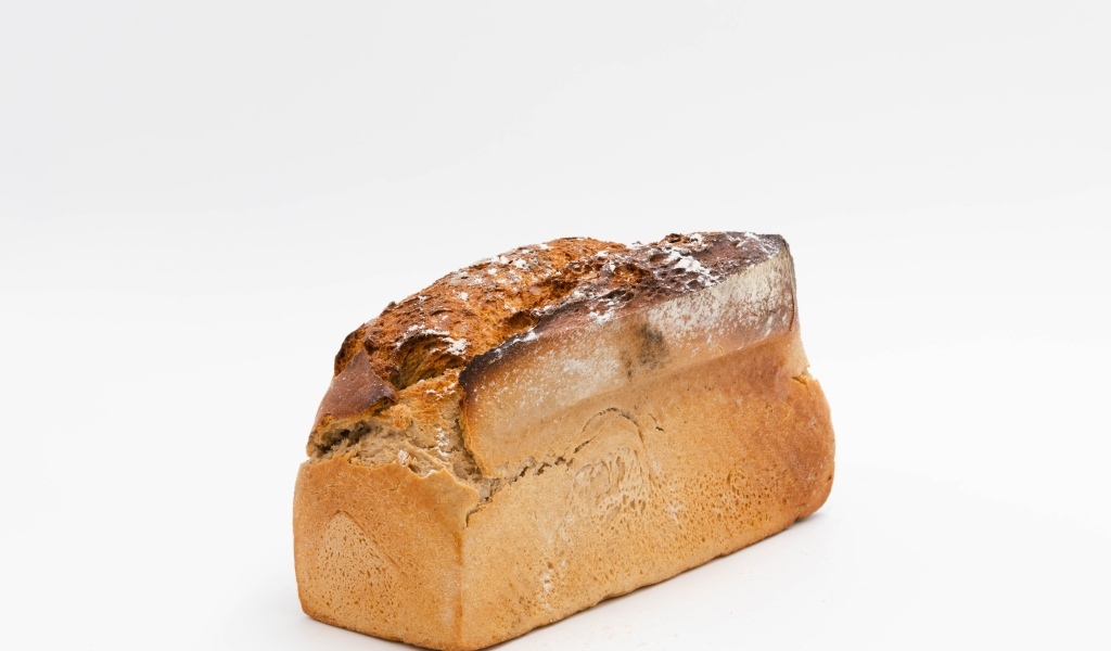 Буханка свежего хлеба на белом фоне