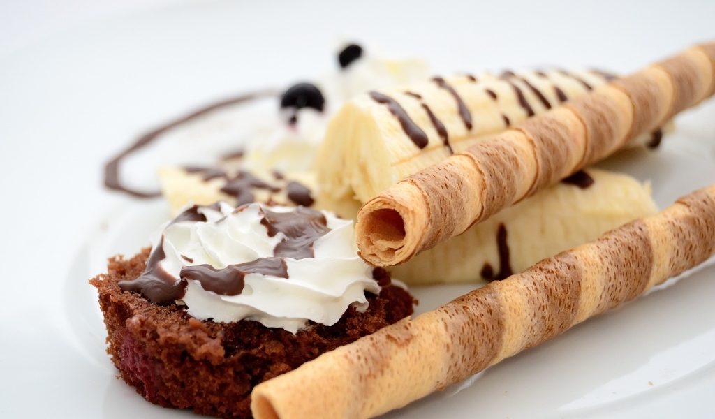 Банан на тарелке с трубочками и кексом