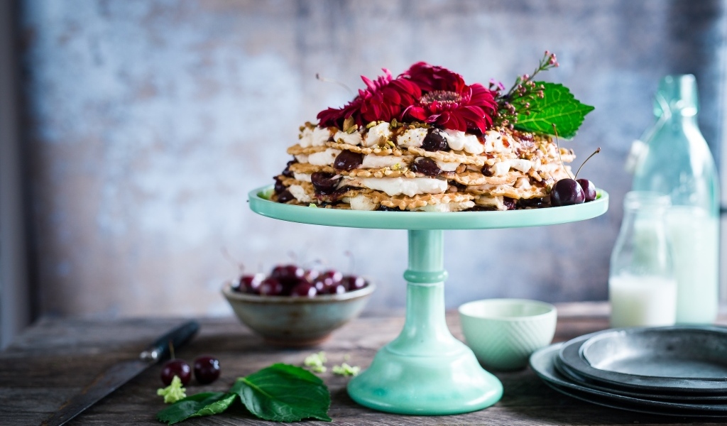 Торт с черешней и цветами герберы на столе