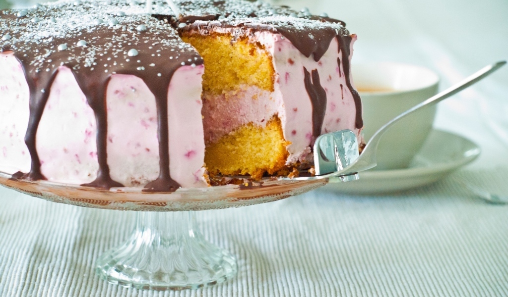 Торт с розовым кремом и шоколадом на столе